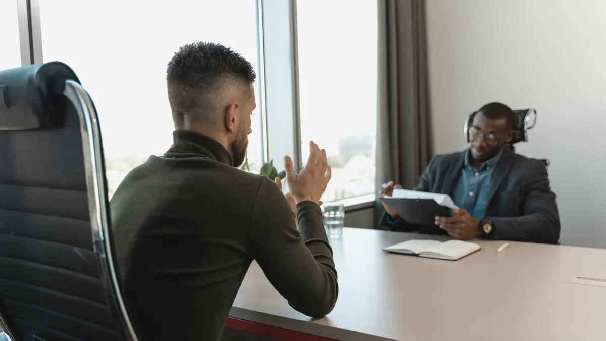 Kenyan job candidate answering interview questions from a hiring manager in an office