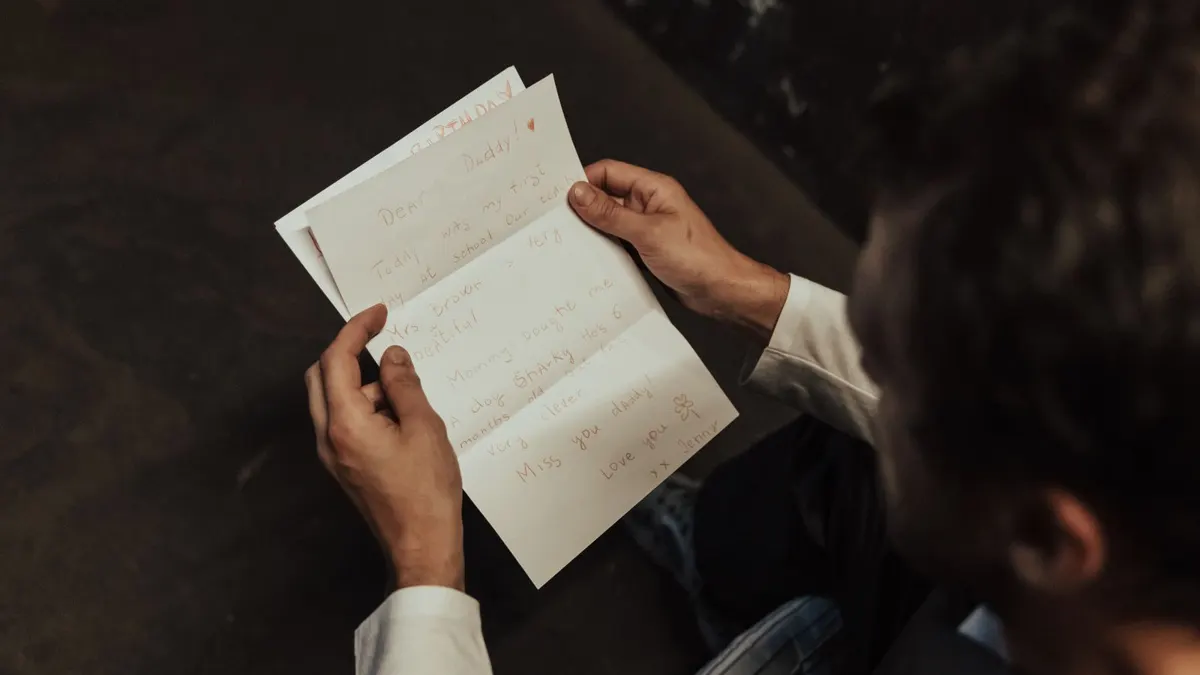 Man holding and reading a typed letter at a table