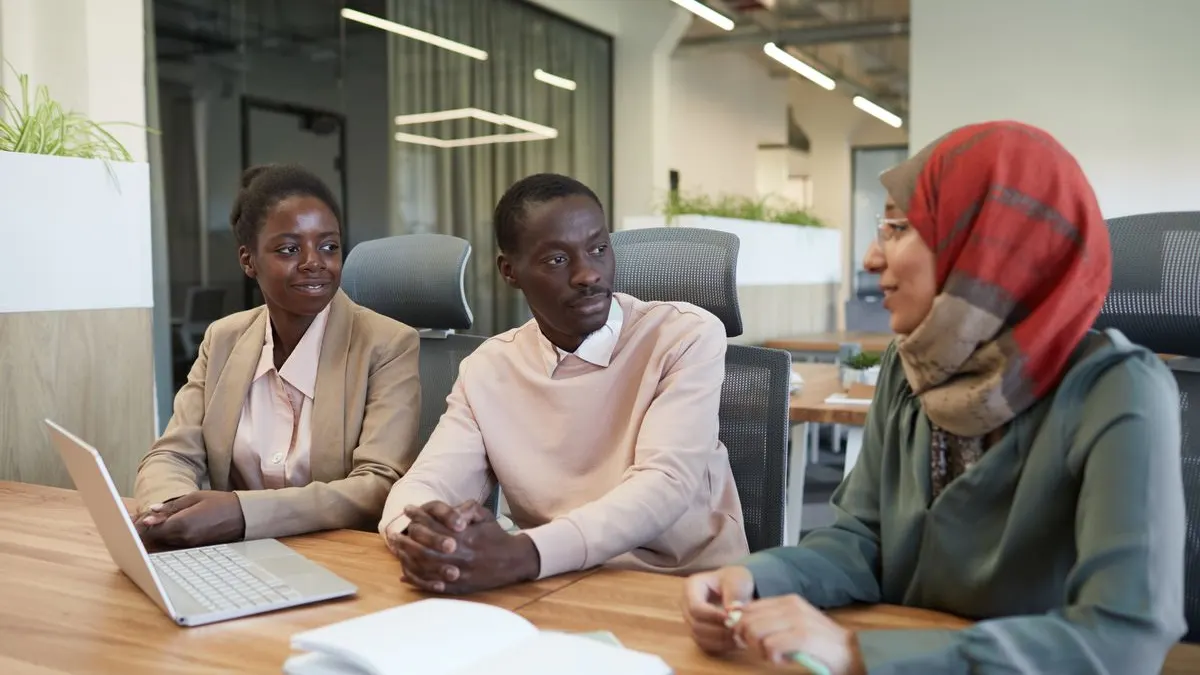 Kenyan employees discussing payslips and salary deductions in an office meeting