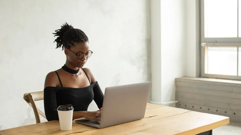 Young Kenyan woman typing a job application cover letter on her laptop
