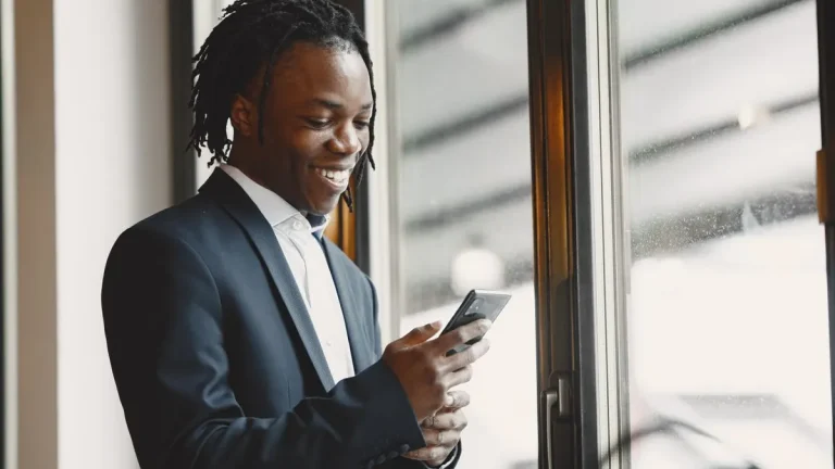 Kenyan professional man updating his LinkedIn profile on a smartphone at work