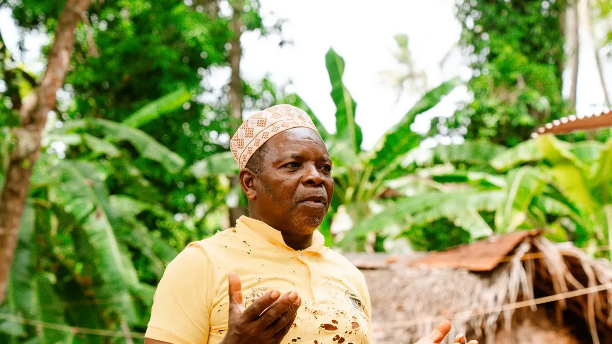 Community leader addressing a seated group at an outdoor village meeting