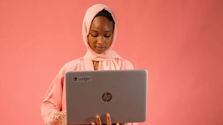 Kenyan woman holding a laptop, ready to work a remote job from home