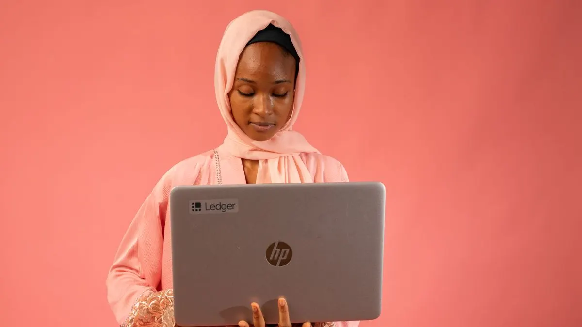 Kenyan woman holding a laptop, ready to work a remote job from home