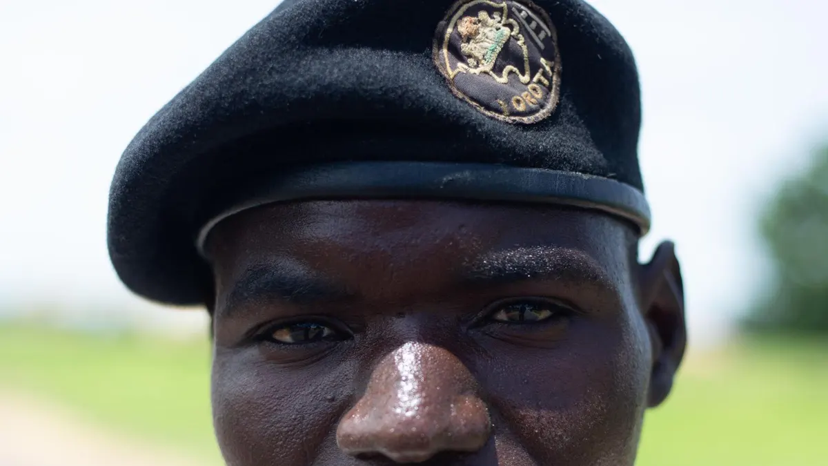 Close-up of a Black security officer wearing a black beret with a badge