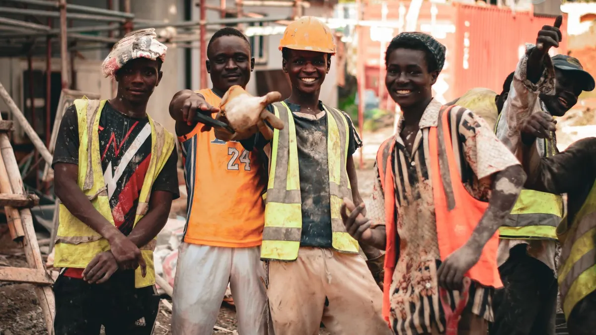 Group of construction workers in hard hats and reflective vests on a building site